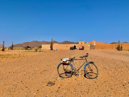a bike parked in the middle of the desert at Riad Ouzina TGM in Ouzina