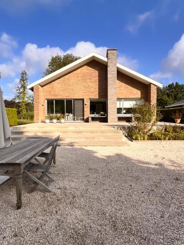 een stenen huis met een bank ervoor bij B&B near Ghent in Merelbeke