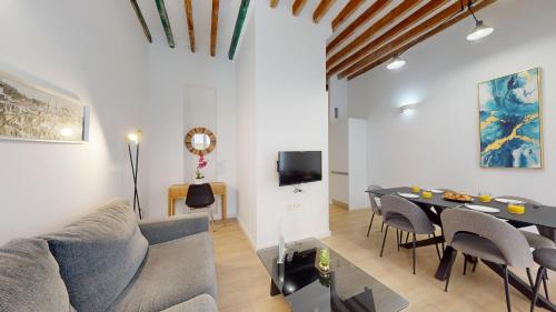 una sala de estar con un sofá, una mesa y sillas en MyFlats Luxury City Center, en Alicante