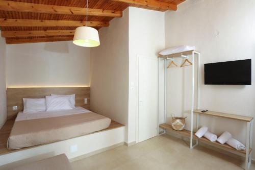 una camera da letto con un letto e una TV a schermo piatto di Scala Village Camping a Vatopedi