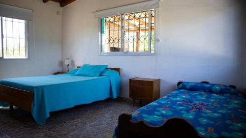 a bedroom with two beds and a window at Las Calandrias in Valle Hermoso