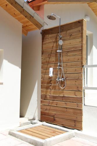 a shower in a room with a wooden wall at Scala Village Camping in Vatopedi