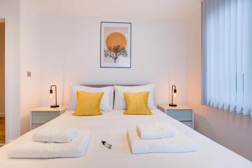 a bedroom with a white bed with two towels on it at Hybrid Resi - London, Greenwich near O2 Arena in London