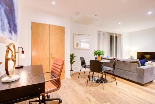 a living room with a couch and a table and chairs at Hybrid Resi - London, Greenwich near O2 Arena in London