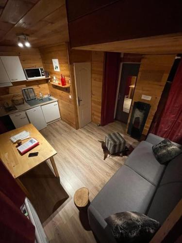 a living room with a couch and a table at Superbe Studio Ambiance Chalet in Ustou