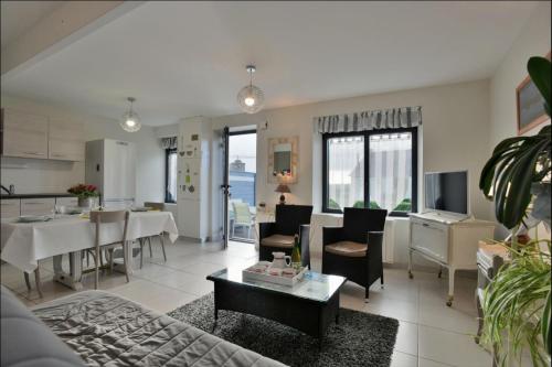 un salon avec un canapé et une salle à manger dans l'établissement Gite 1 L Logis des Grenouilles, à Lamballe Armor