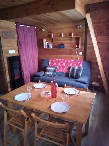 - une salle à manger avec une table en bois et un canapé dans l'établissement Superbe Studio Ambiance Chalet, à Ustou
