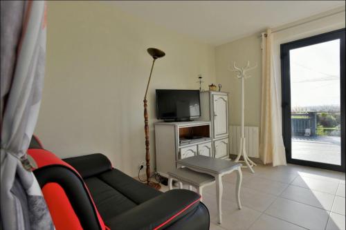 un salon avec un canapé et une télévision dans l'établissement Gite 2 Le Logis des grenouilles, à Lamballe Armor