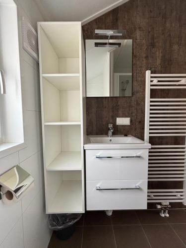 a white bathroom with a sink and a mirror at Vakantiepark Schouwen in Renesse