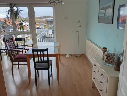 Un comedor con mesa y sillas y un balcón. en Ferienwohnung in Langgöns, en Langgöns