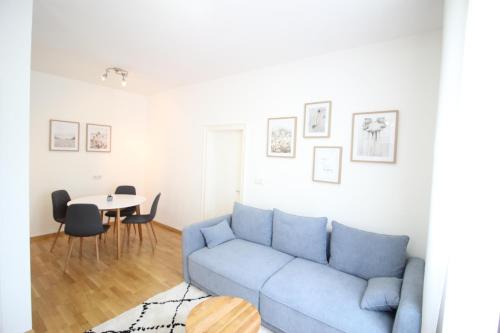 a living room with a blue couch and a table at Smarthotel Schmid in Sitzenberg