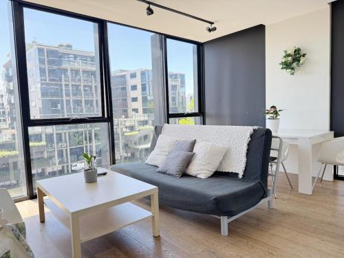 a living room with a couch and some windows at FutureStay AI in Melbourne