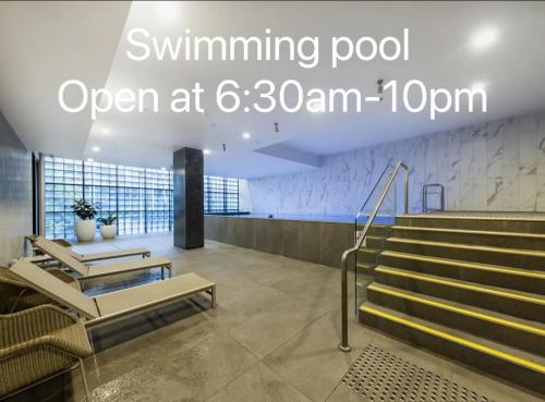 a lobby with stairs and a sign that reads swimming pool open at at FutureStay AI in Melbourne