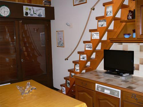 une chambre avec un escalier et une télévision sur un comptoir dans l'établissement Aiguille de Mey 12, à Pralognan-la-Vanoise