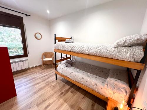 a room with two bunk beds and a window at Apartaments Casa Mata - L'Amfitriona in Esterri d'Àneu