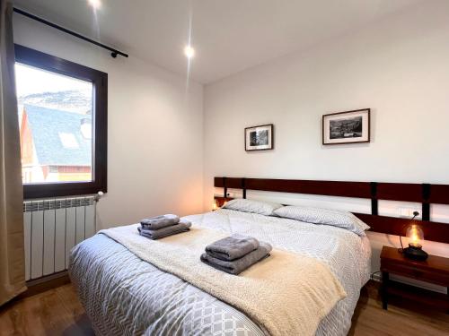 a bedroom with a bed with two towels on it at Apartaments Casa Mata - L'Amfitriona in Esterri d'Àneu