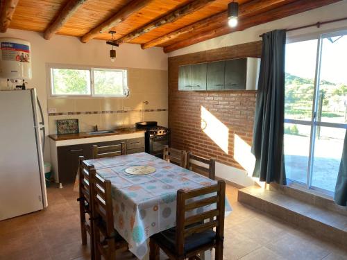 a kitchen with a table with chairs and a refrigerator at El Rincon de las Marias Casa en Planta Alta in San Lorenzo