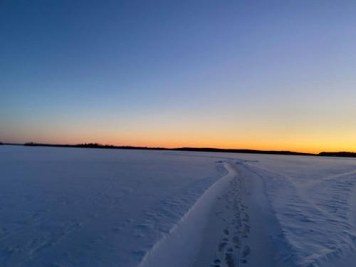 a snow covered field with footprints in the snow at 4 bedroom house close to nature and adventure in Hulu
