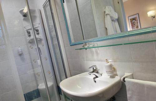 La salle de bains blanche est pourvue d'un lavabo et d'une douche. dans l'établissement Hotel San Giovanni Terme, à Ischia