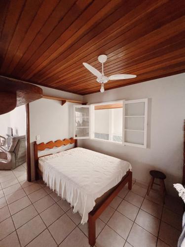 a bedroom with a bed with a wooden ceiling at Casa 50m do mar in Matinhos