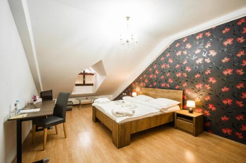 a bedroom with a bed and a desk and a staircase at Hotel Panský dům in Kostelec nad Orlicí