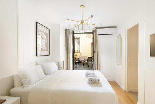 - une chambre blanche avec un lit blanc et un lustre dans l'établissement Modern 3 Bedrooms 3 Baths Full Center of Paris, à Paris