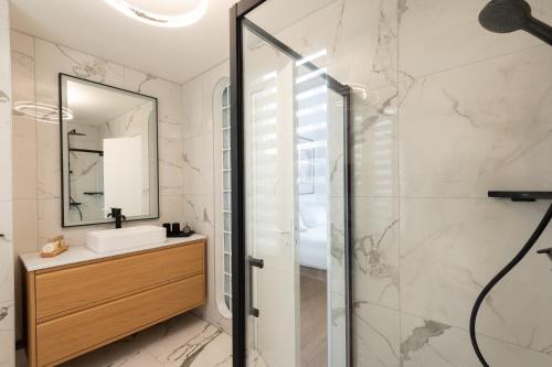 une salle de bain avec un lavabo et une douche dans l'établissement Modern 3 Bedrooms 3 Baths Full Center of Paris, à Paris