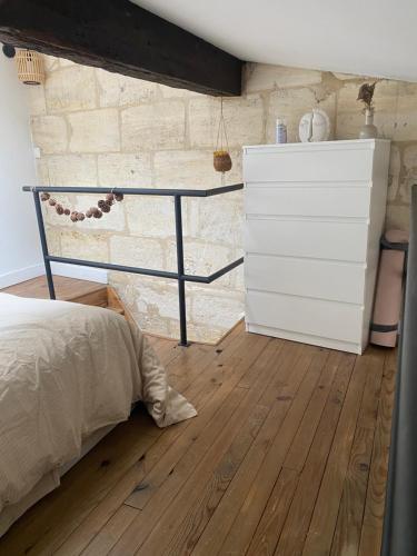 une chambre avec un lit et une commode dans l'établissement Escapade Cosy charme Bordelais centre, à Bordeaux