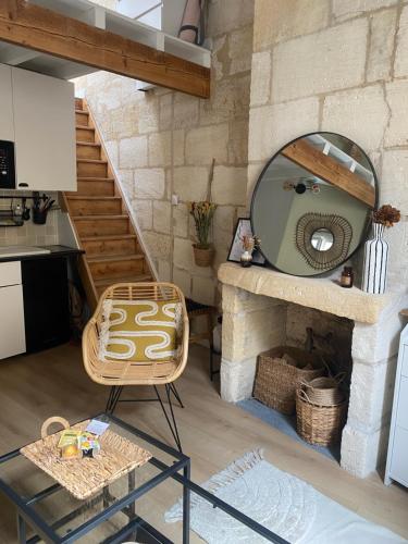 Cette chambre comprend un miroir, une chaise et une cheminée. dans l'établissement Escapade Cosy charme Bordelais centre, à Bordeaux
