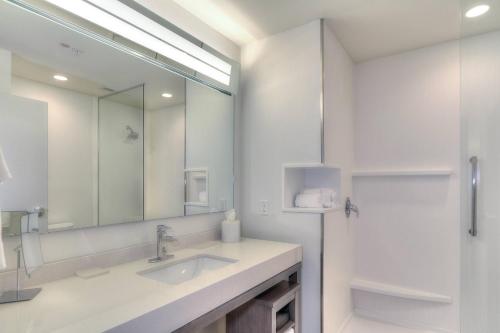 a white bathroom with a sink and a mirror at Courtyard by Marriott Pigeon Forge in Pigeon Forge