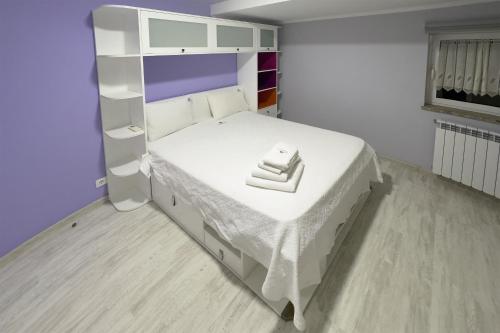 a small bedroom with a white bed and a shelf at Ecofurtado in Furtado