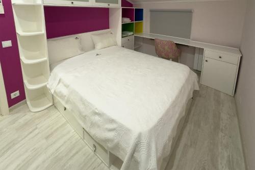a small bedroom with a white bed and shelves at Ecofurtado in Furtado