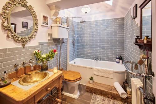 a bathroom with a sink and a tub and a mirror at Host & Stay - Lilac Cottage in Morpeth