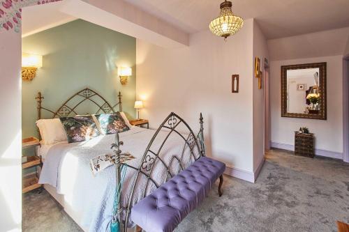 a bedroom with a bed with a purple bench in it at Host & Stay - Lilac Cottage in Morpeth