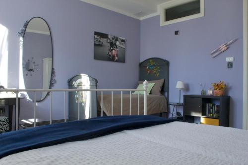 a bedroom with blue walls and a bed with a mirror at B&B Il Riccio in Tirano