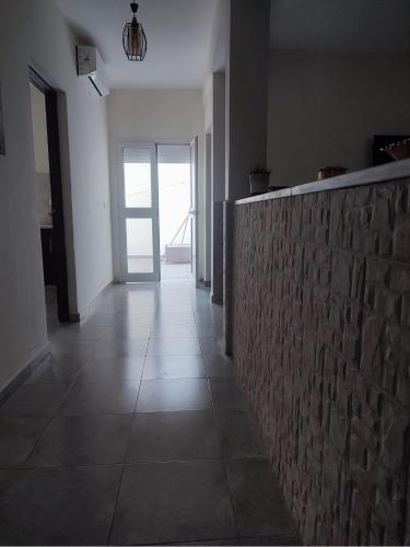 a hallway with a stone wall and a door at Appartement Nature & Plage in Menzel Jemil