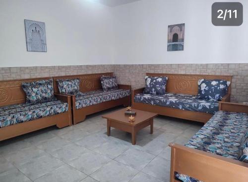 a room with couches and a table in a room at Appartement Nature & Plage in Menzel Jemil