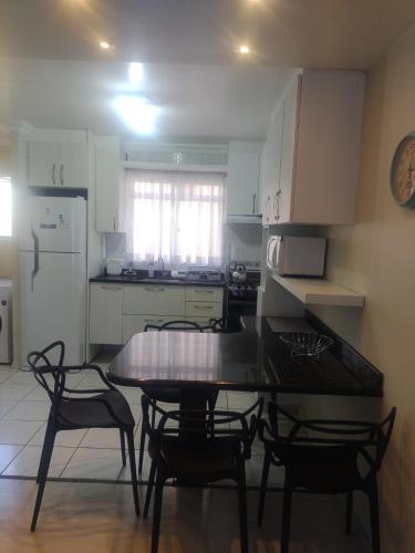 a kitchen with a table and chairs and a refrigerator at B&B Apartamento a 10 minutos do Aeroporto in São José dos Pinhais