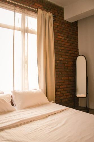 a bedroom with a white bed and a window at R and H Stay in Kohīma