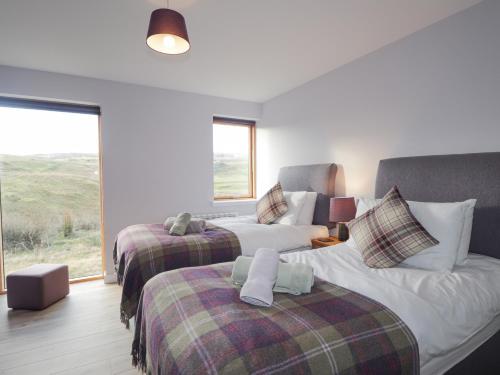 a bedroom with two beds and a couch at Skye Falls Chalet in Milovaig