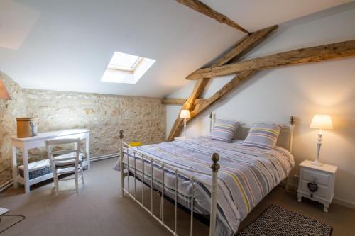 Un dormitorio con una cama y un escritorio. en La maison de lolo et marco pour 6, en Champagnac-de-Bélair
