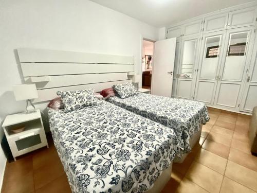 Un dormitorio con dos camas y una lámpara. en Casa Valdes Los Cristianos Center, en Los Cristianos