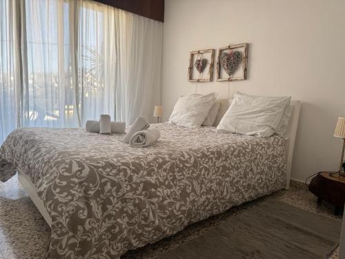 a bedroom with a large bed with a large window at Nikolas and Persefoni Flats in Yeroskipou