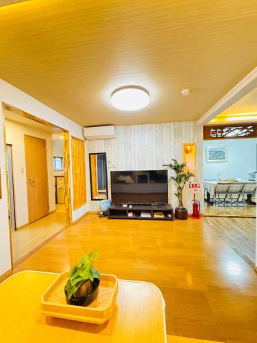 a living room with a table and a tv at 晶 距离车站步行5分钟 关西机场难波心斋桥直达 5 bedroom最多可住13人 超大客厅大电视有Netflix in Osaka