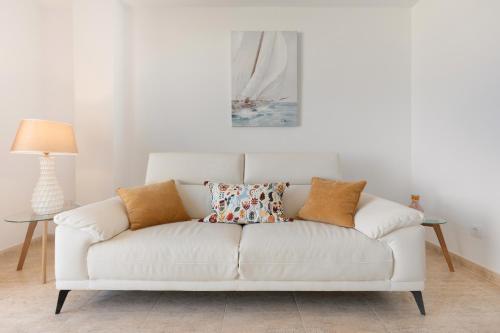 a white couch with pillows on it in a living room at Casa del mar in Costa Calma