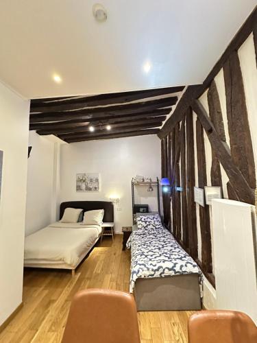 une chambre avec deux lits et une table et des chaises dans l'établissement St Paul Marais Flat Ground Floor, à Paris