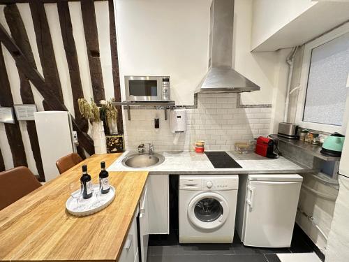 une cuisine avec un évier et une machine à laver dans l'établissement St Paul Marais Flat Ground Floor, à Paris