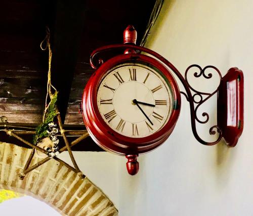 a red clock on a wall with a heart on it at country house in Ardea