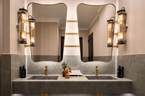 a bathroom with two sinks and a large mirror at The Chemists Club Hotel in New York