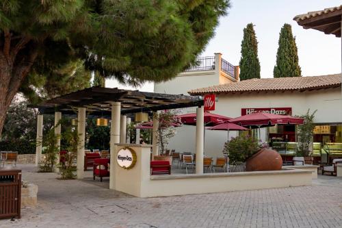 a restaurant with tables and chairs and umbrellas at HG07 Adjacent to Aphrodite Hills- Private Pool, Large Terrace in Kouklia